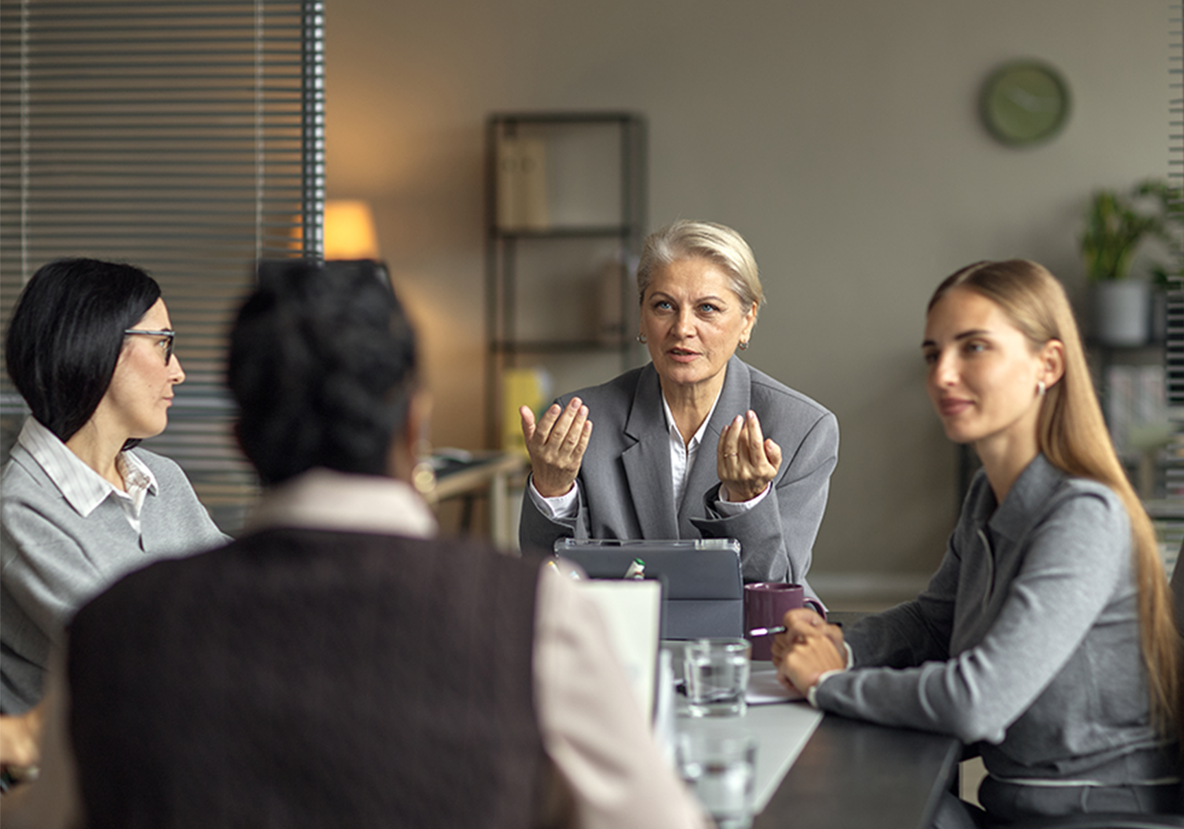 senior-caucasian-woman-leading-business-meeting-with-diverse-female-colleagues_resized@2x.png